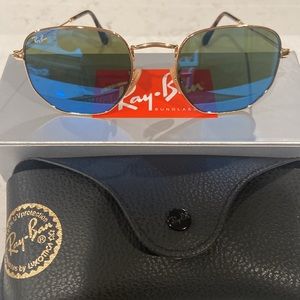 NEVER WORN AUTHENTIC RAY-BAN with blue reflective lenses and gold frames.